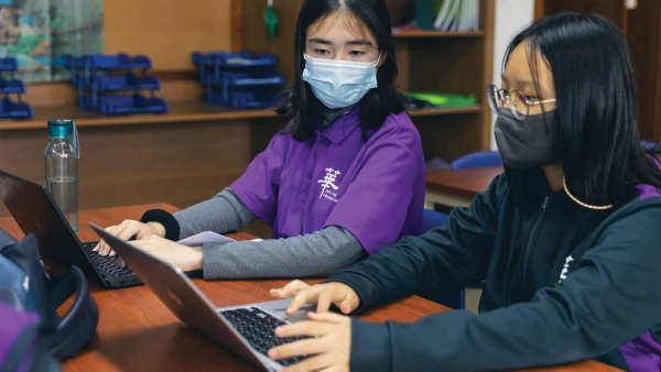 烟台华盛国际学校的两名女学生正在用笔记本电脑学习