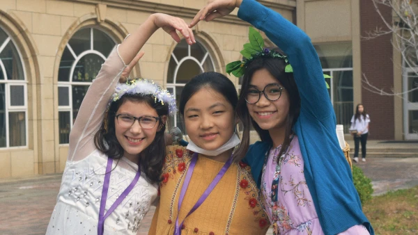 three female students posing outside yantai huasheng international school