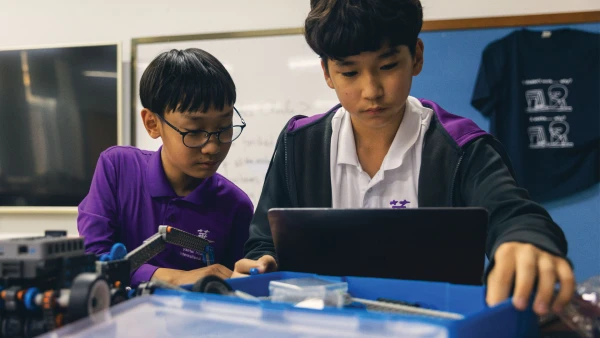 two male students working with robotics at yantai huasheng international school middle school