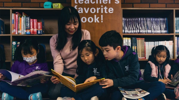 yantai huasheng international school teacher with four students reading books
