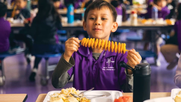 yantai huasheng international school campus cafeteria with food on a stick enjoyed by a young male student